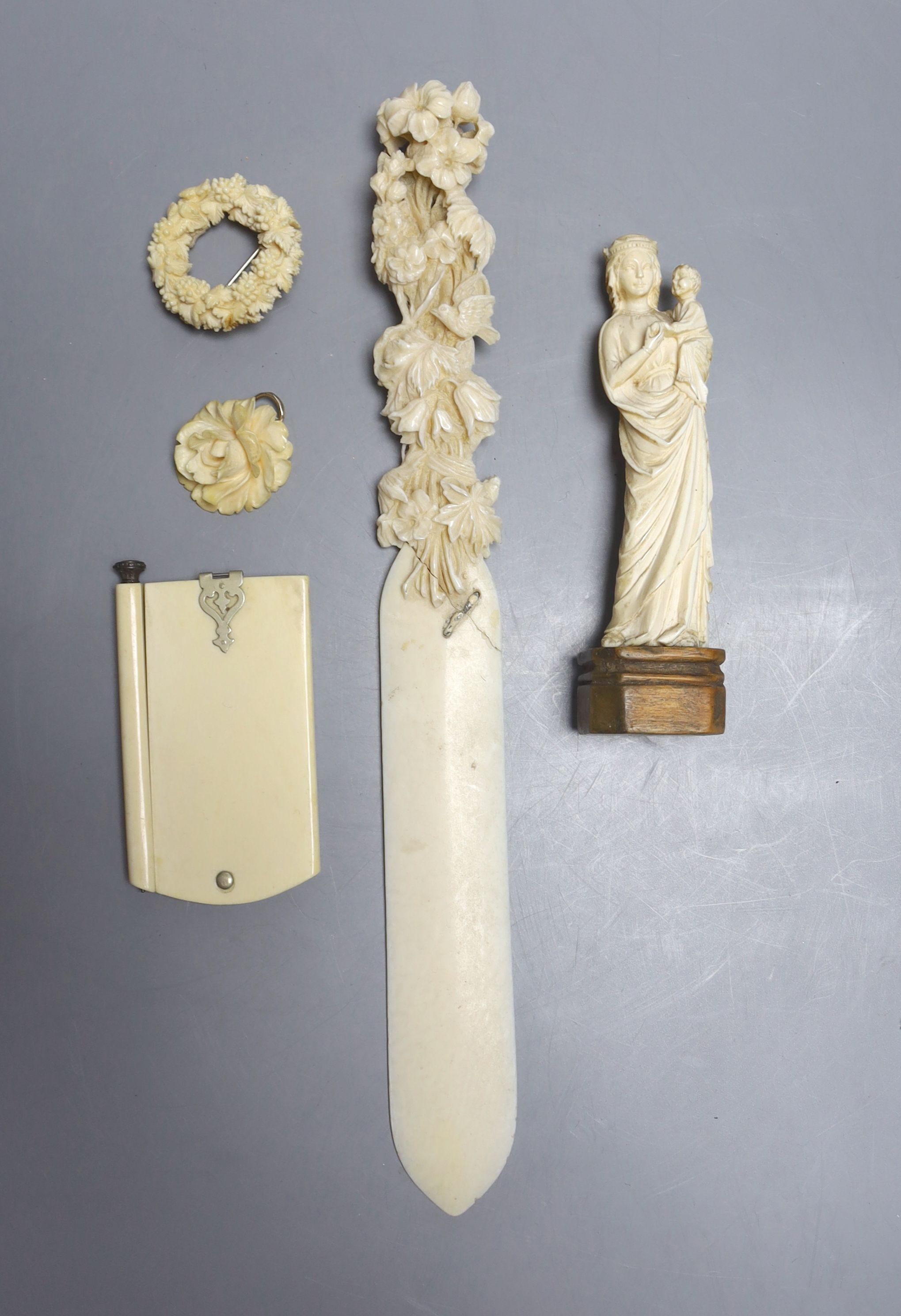 A 19th century carved ivory Madonna child, an ivory figural carving, a pendant, a brooch, a page turner and a diary